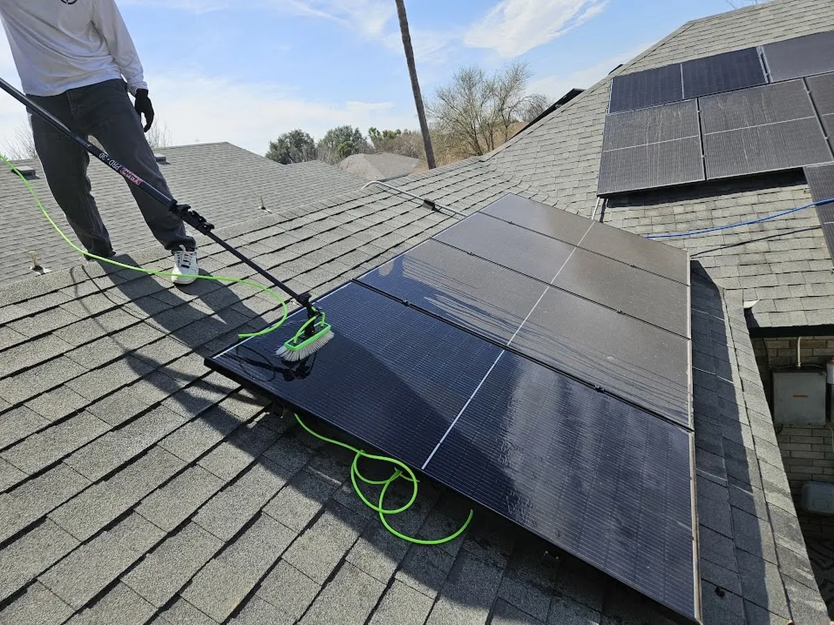 Otto's technician working across a steep roof to clean solar panels