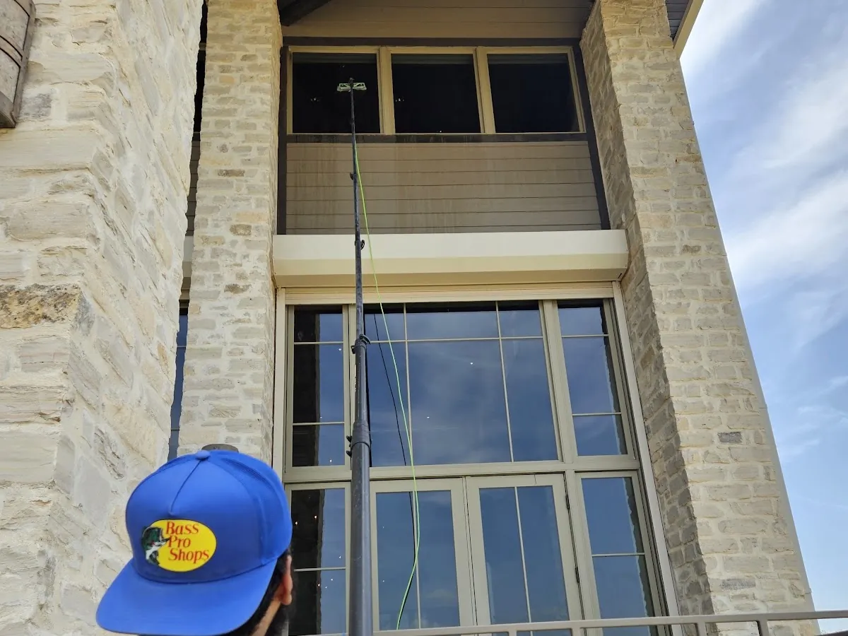 Otto's technician cleaning tall second-story windows with a water-fed pole