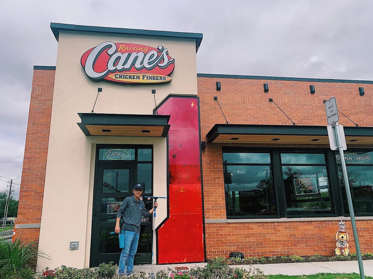 Otto's technician cleaning the windows of a Raising Cane's restaurant